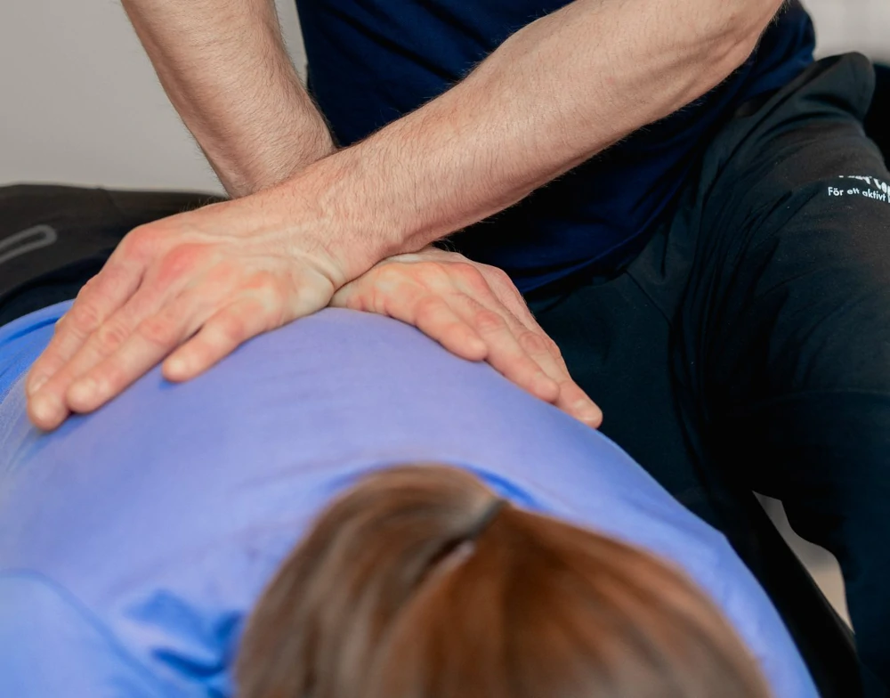 Naprapat behandlar smärta i bröstryggen på en patient